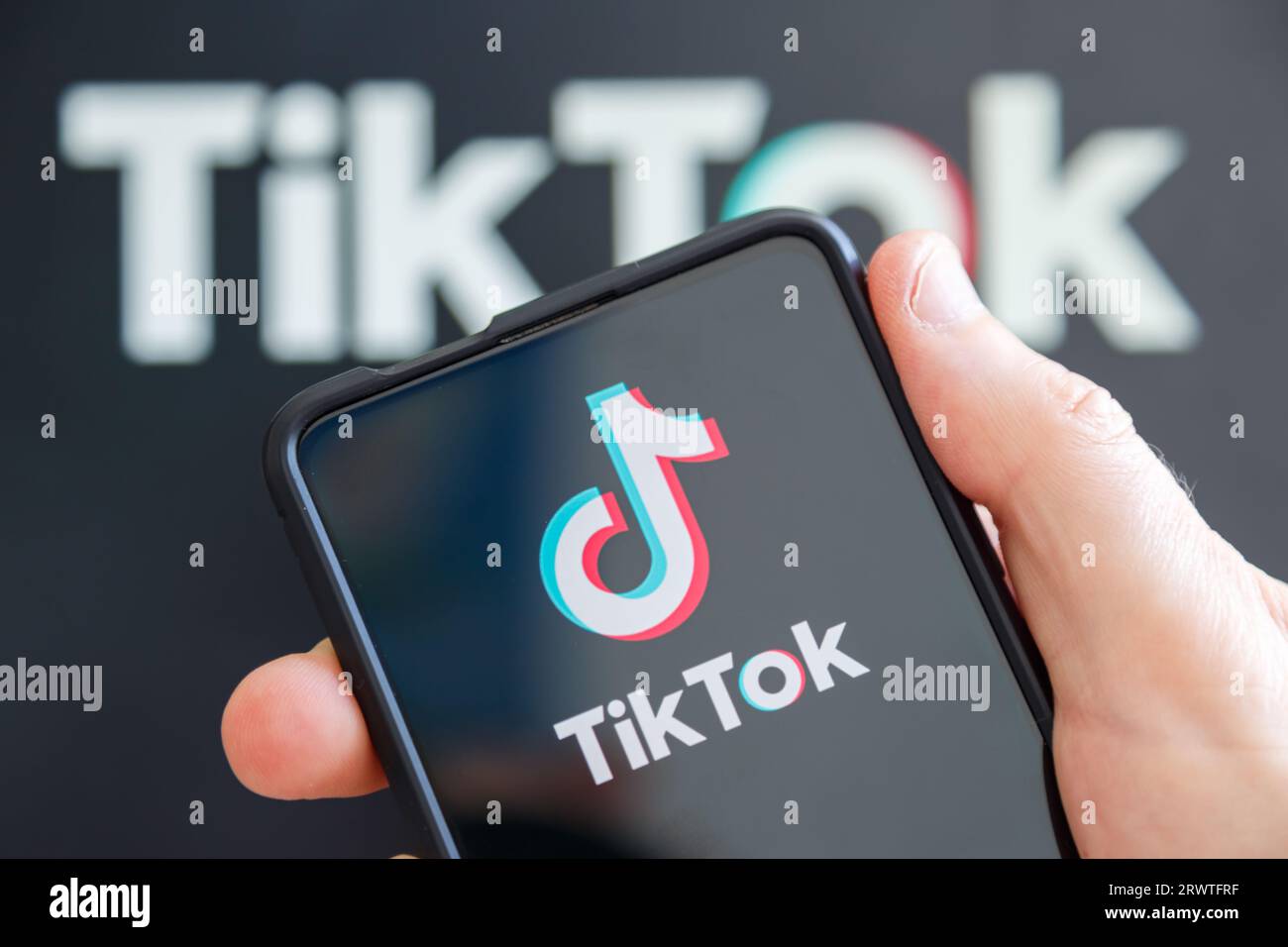 Stuttgart, Germany - July 20, 2023: Hand holding a mobile phone with TikTok logo social media computer screen in Stuttgart, Germany. Stock Photo