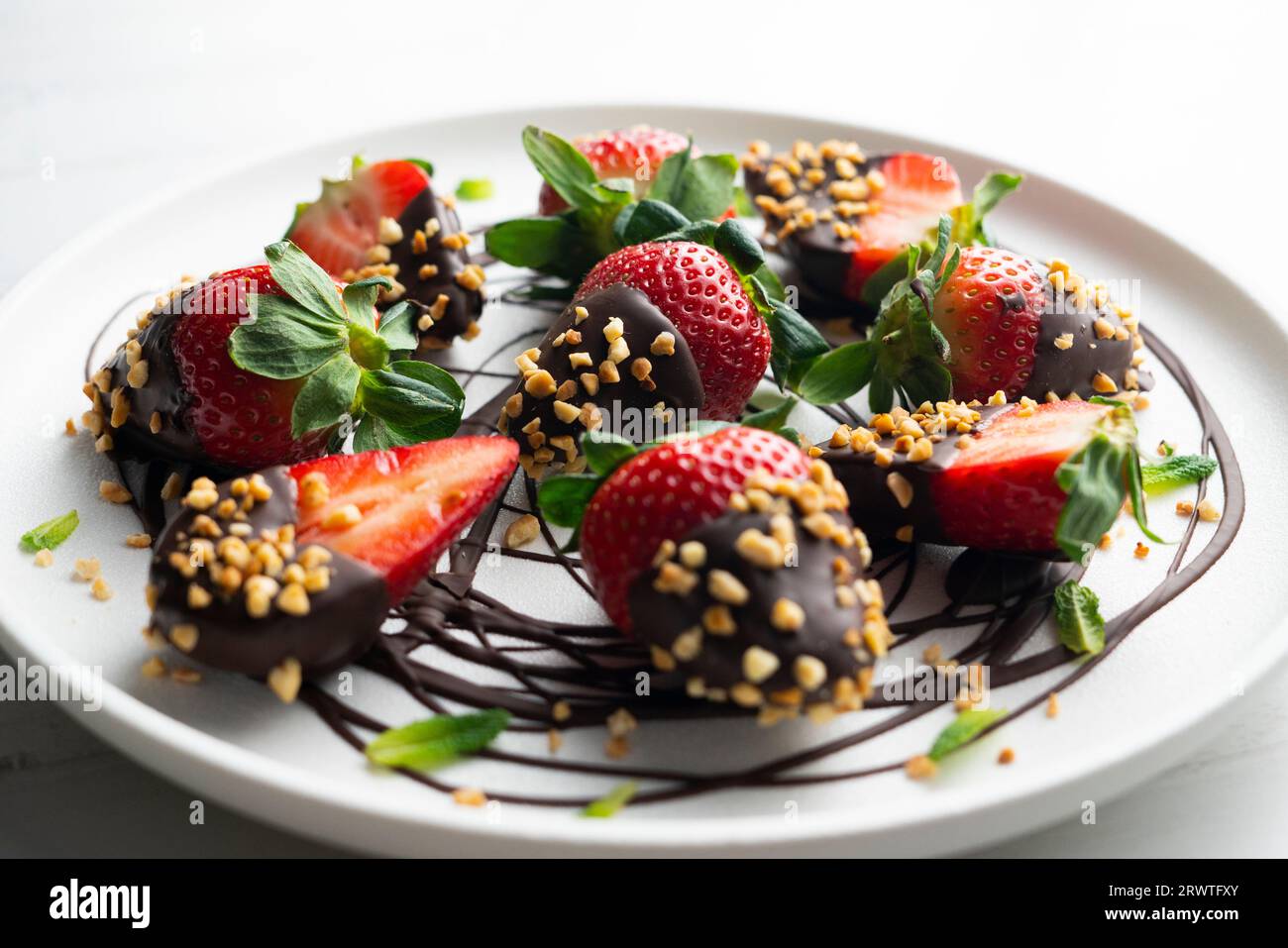 Strawberries dipped in dark chocolate and coated with toasted almonds. Stock Photo