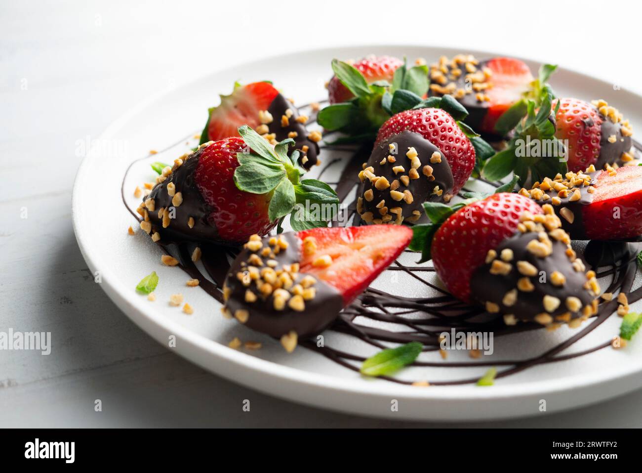 Strawberries dipped in dark chocolate and coated with toasted almonds. Stock Photo