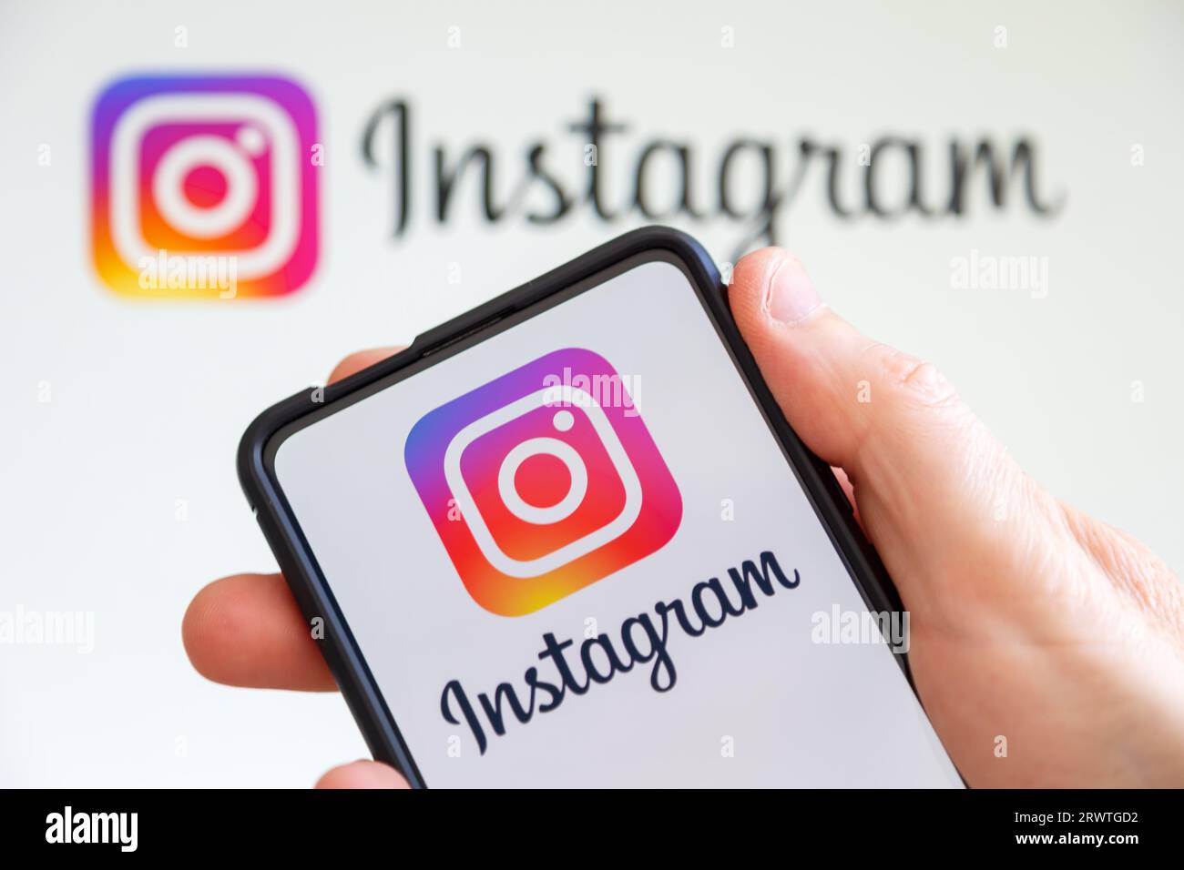 Stuttgart, Germany - July 20, 2023: Hand holding a mobile phone with Instagram logo social media computer screen in Stuttgart, Germany. Stock Photo