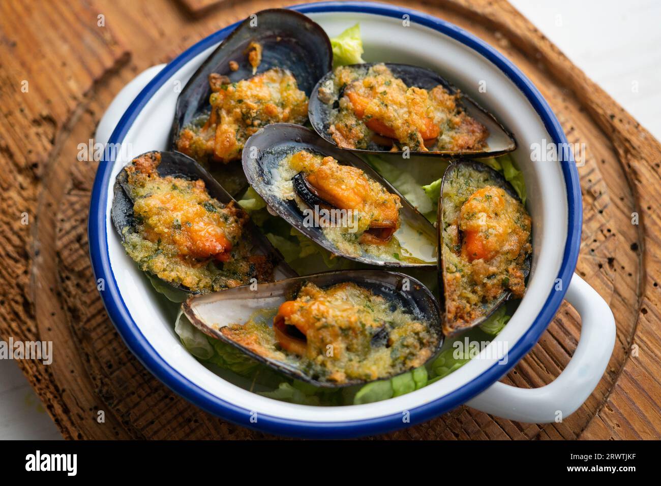 Mussels gratin. Gratin seafood dish with bread and parsley. Stock Photo