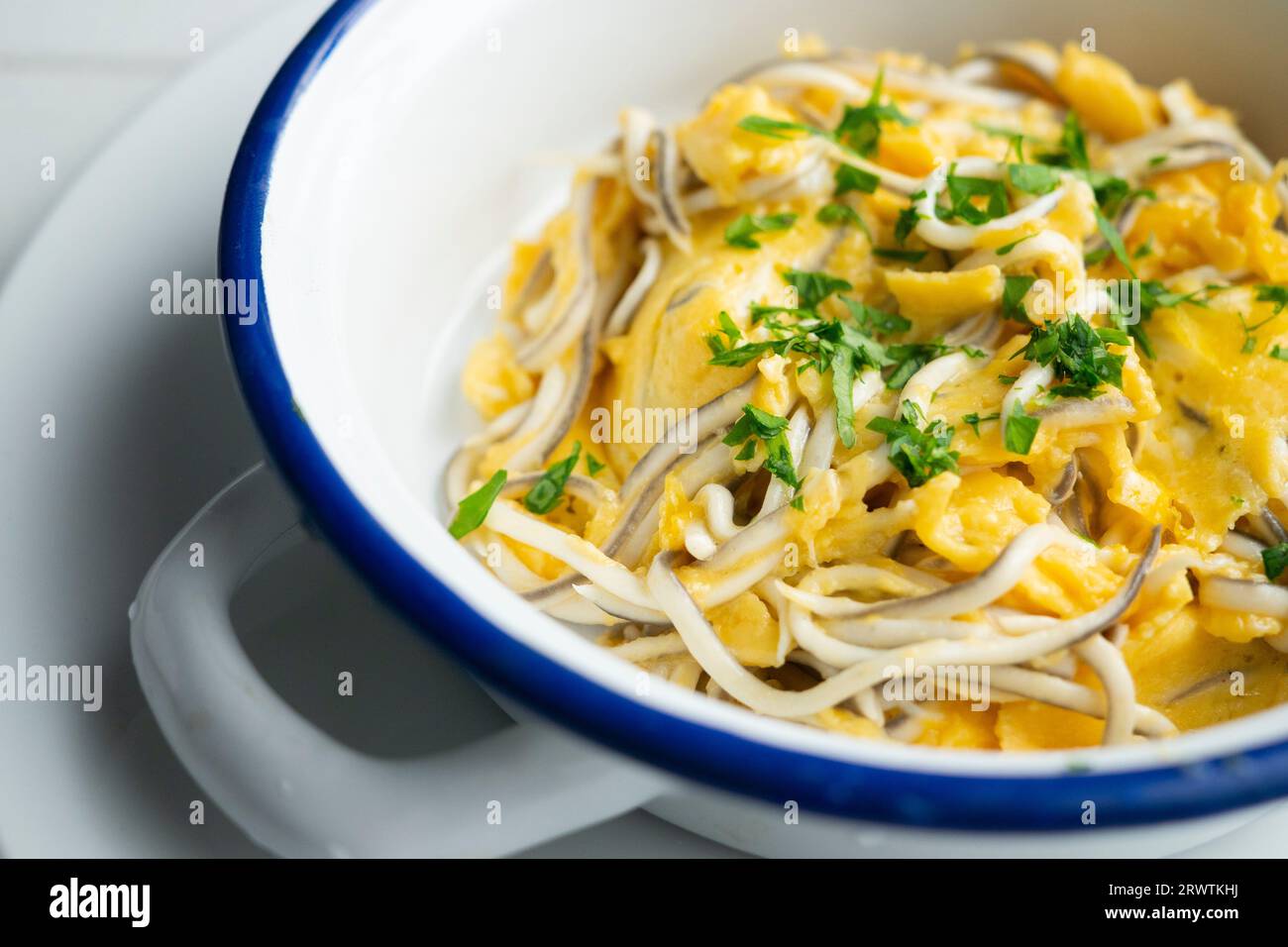 Scrambled eels with garlic. Traditional Spanish tapa. Stock Photo