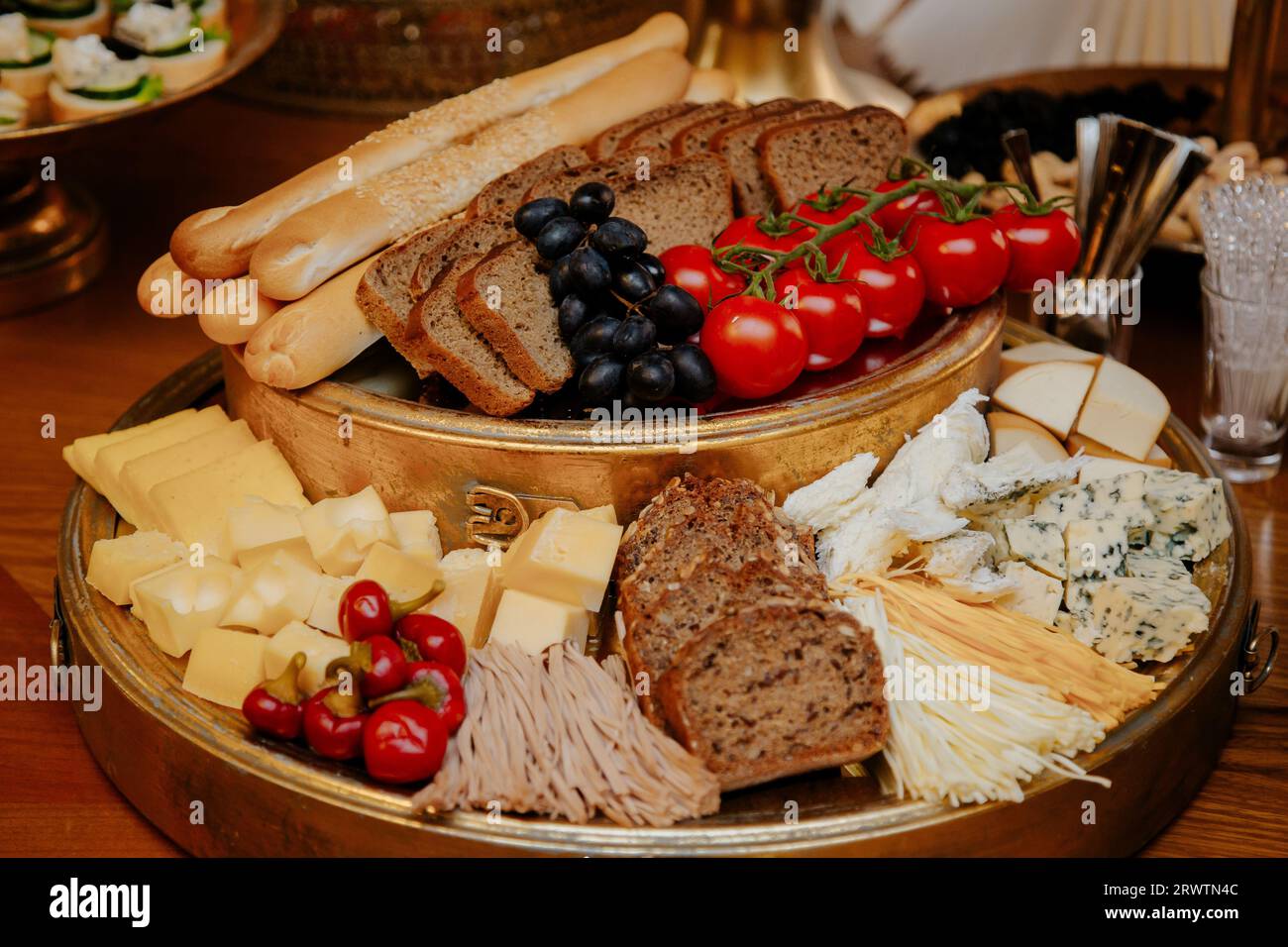 An artisanal platter featuring an array of cured meats, artisan breads, and a selection of cheeses. Stock Photo