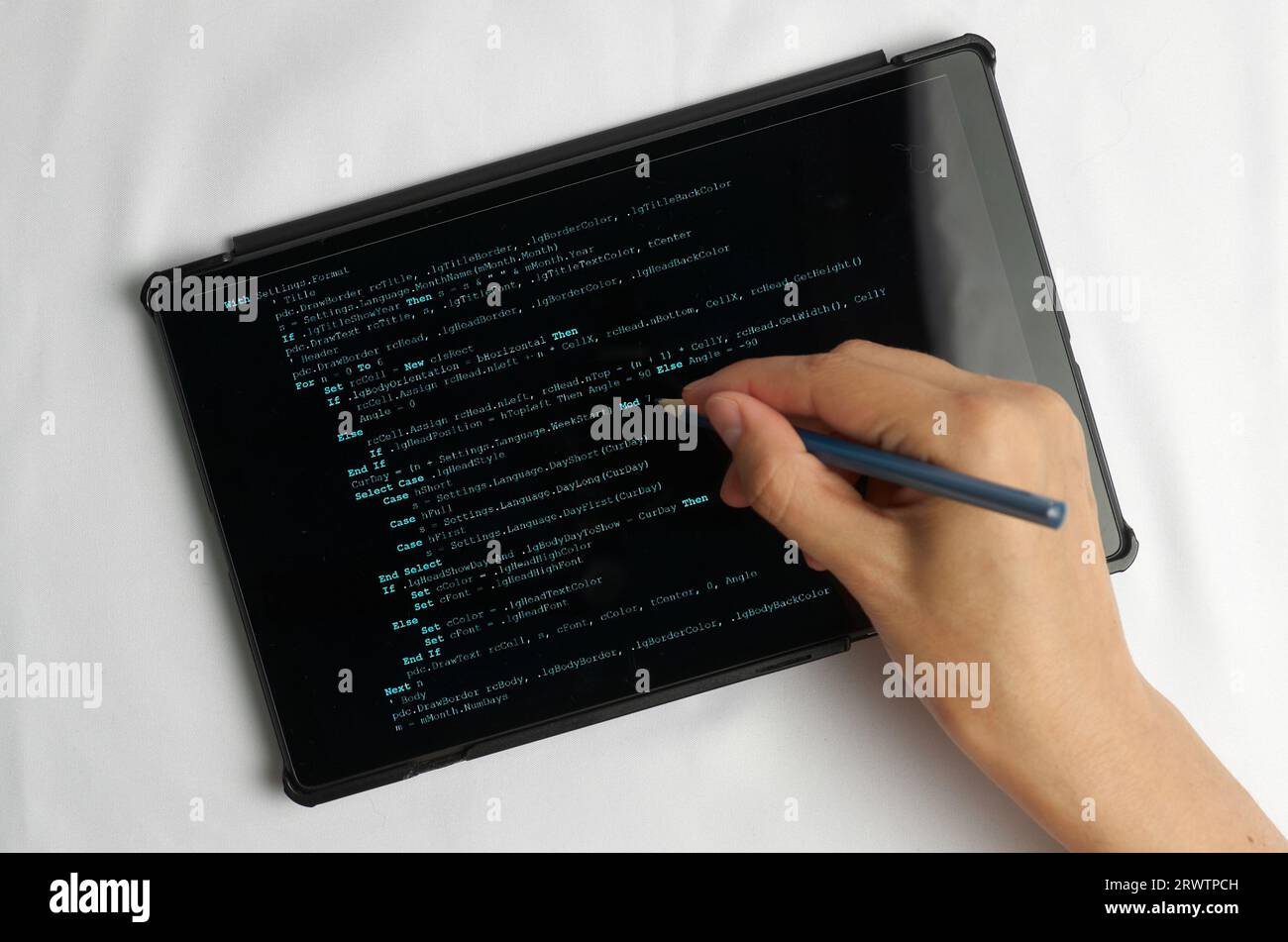Programming and coding concept. A hand with a pencil writes a program listing on the screen Stock Photo