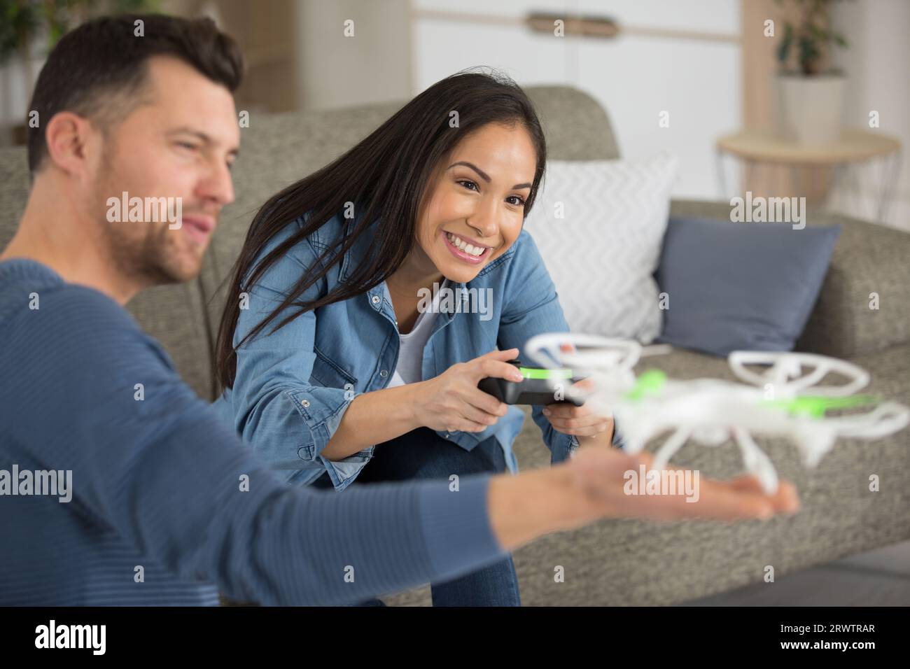 couple is operating a drone at home Stock Photo