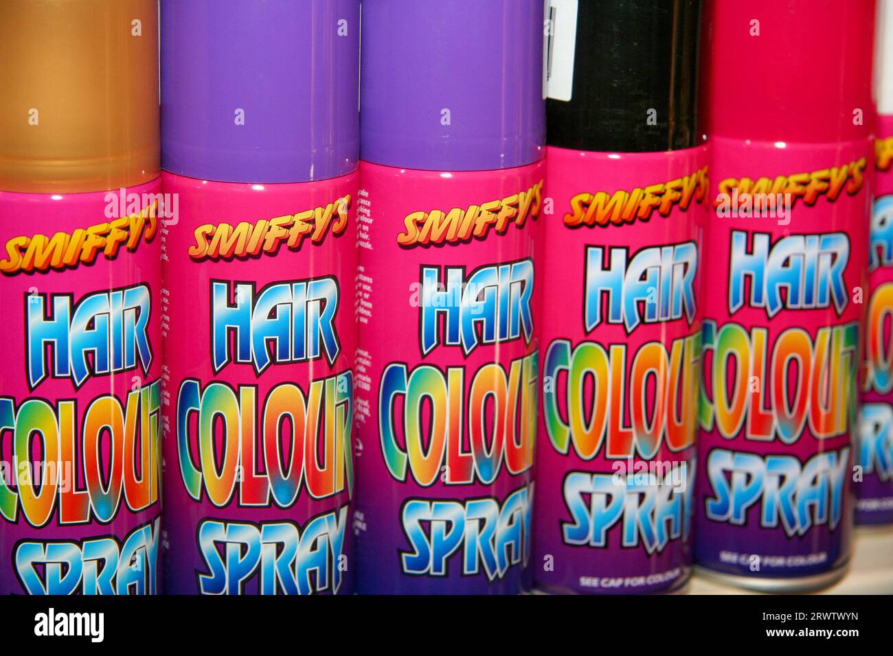 Five cans of Smiffy's brand hair colour spray in a row and for sale in an independent retailers Stock Photo