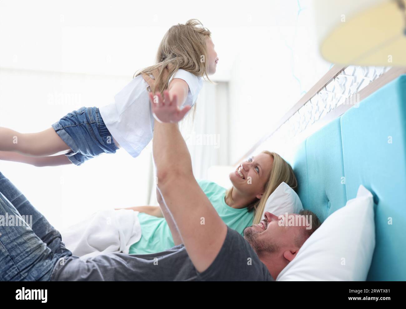 Dad is holding child in outstretched arms above him Stock Photo