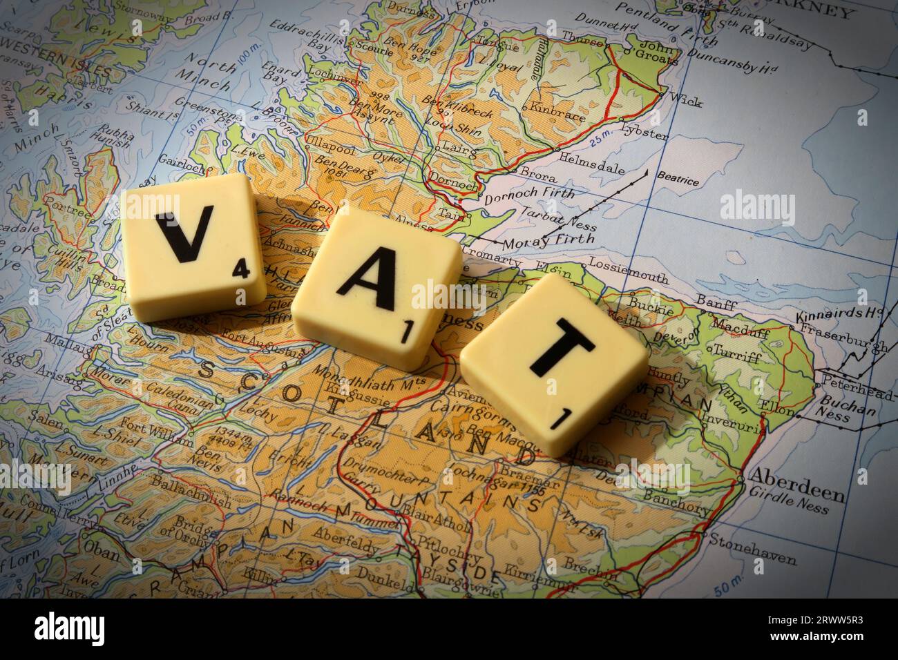 VAT the purchase Value Added Tax spelled out in Scrabble letters on a map of Scotland, Great Britain, UK Stock Photo