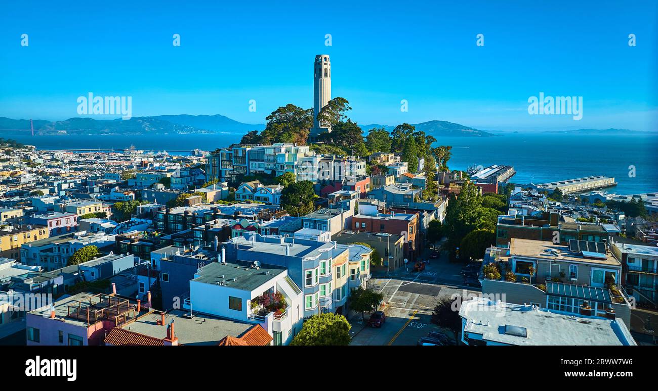Coit Tower on Telegraph Hill behind tall apartment buildings with San