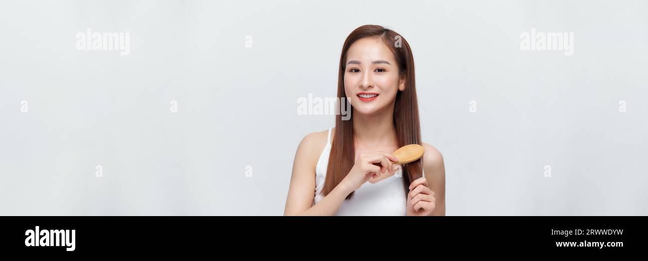 Pretty asian woman is combing her hair isolated on the white background. panorama Stock Photo