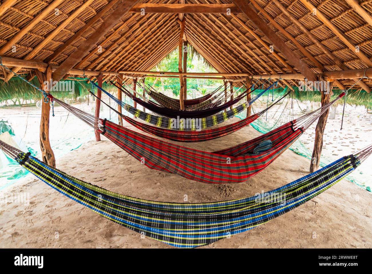 Hammocks hanging under rustic indigenous hut in Brazil Stock Photo