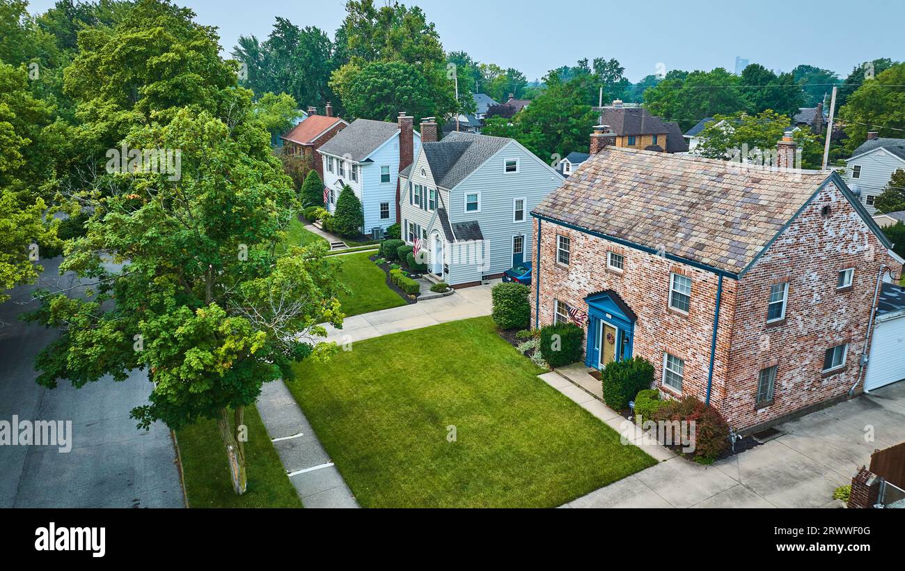 Aerial of houses off Pemberton Dr with old brick building and neatly trimmed green lawns Stock