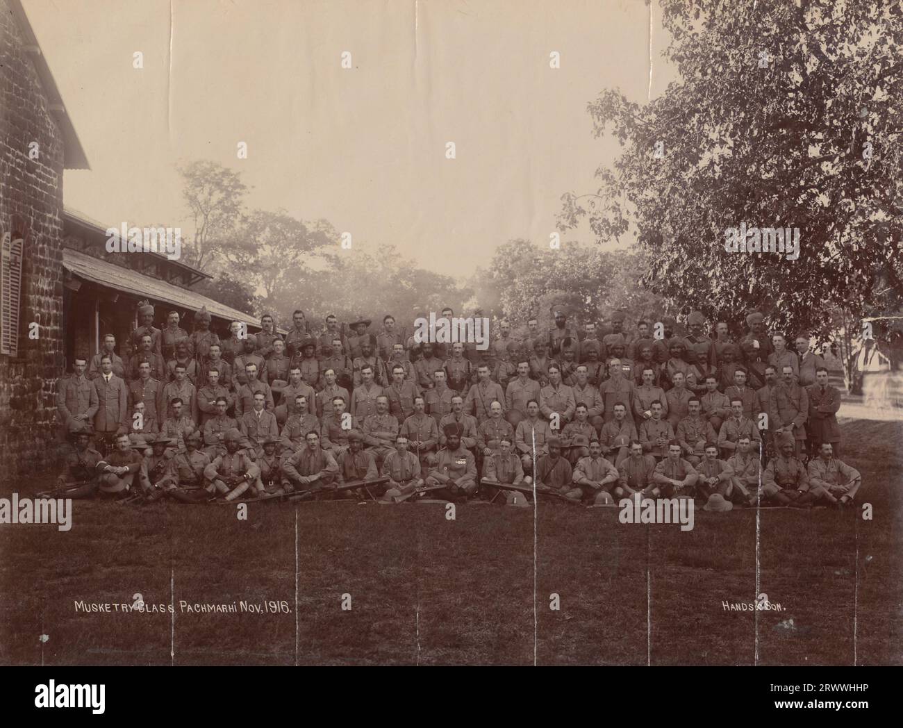 Trainee British and Indian musketeers pose for a group portrait with their rifles outside the School of Musketry at Pachmarhi. Winthrop studied for this course at Pachmarhi from October -December 1916.  Printed caption: Musketry Class Pachmarhi Nov, 1916. Hands & Son. Stock Photo
