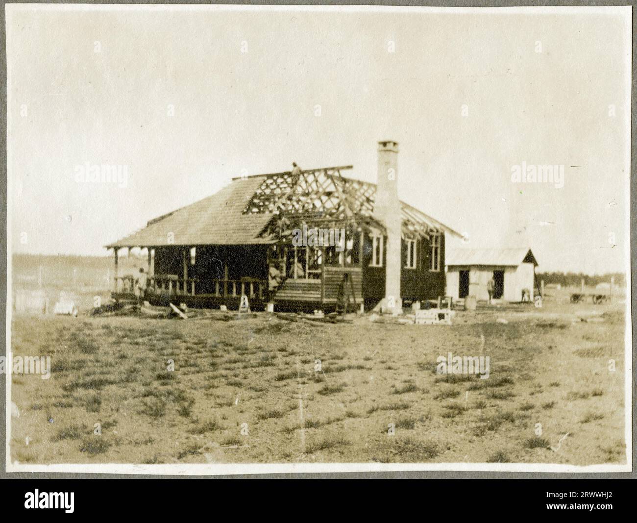 Work in progress photograph of a partially built bungalow showing the walls, chimney, rafters and some of the roof tiling in place. Part of a series showing this structure, built by Public Works Dept. apprentices for their instructor Mr Bungey in early 1922. Stock Photo