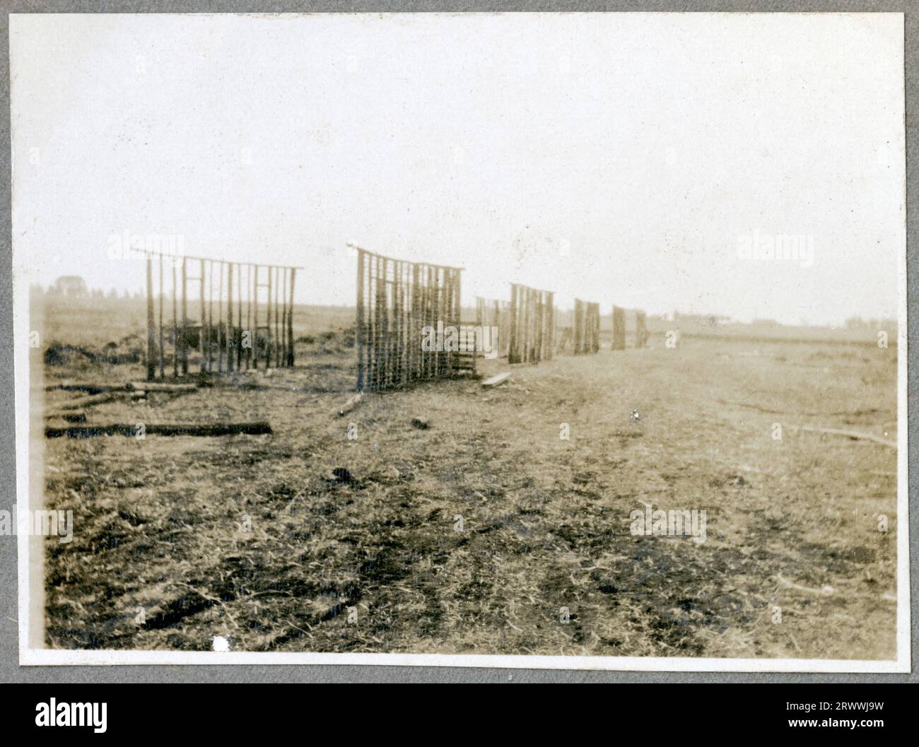 Apprentice masons building first courses of a house; completed houses