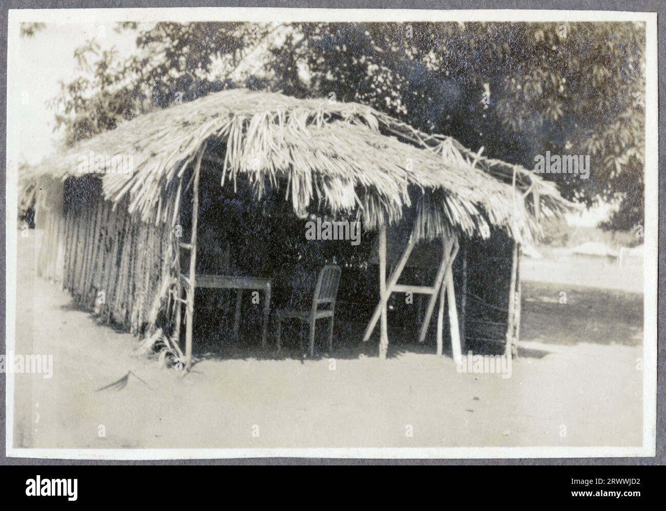 Apprentice masons building first courses of a house; completed houses