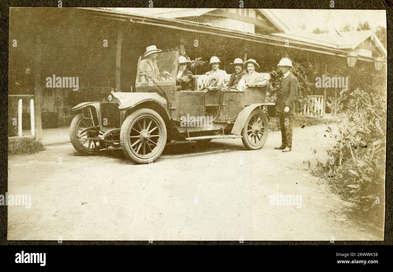 A car is parked outside a one storey building containing six men wearing pith helmets. Charles Bungey's brother William Walter was at one time manager of the Nakuru Hotel.  Original manuscript caption: Nakuru Hotel. Stock Photo