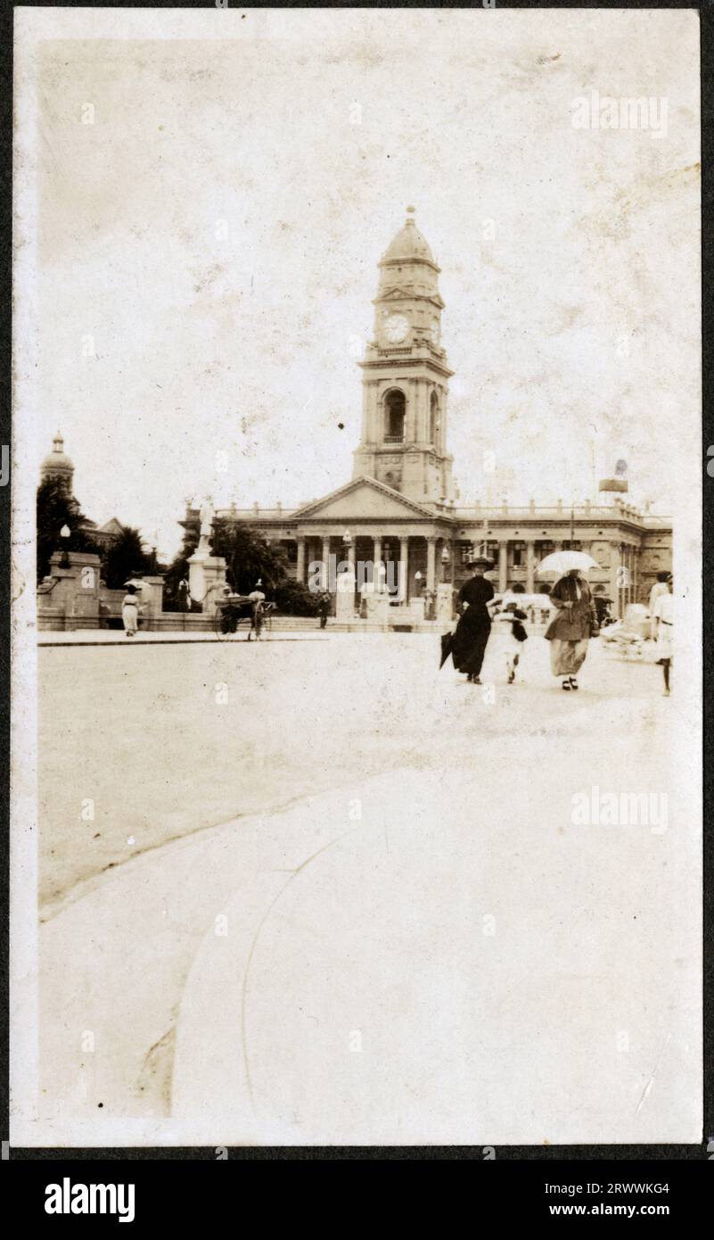 Front elevation of the central Post Office in Durban, seen from along the street. A rickshaw is visible and there are people crossing the road. Original manuscript caption: Post Office. Stock Photo