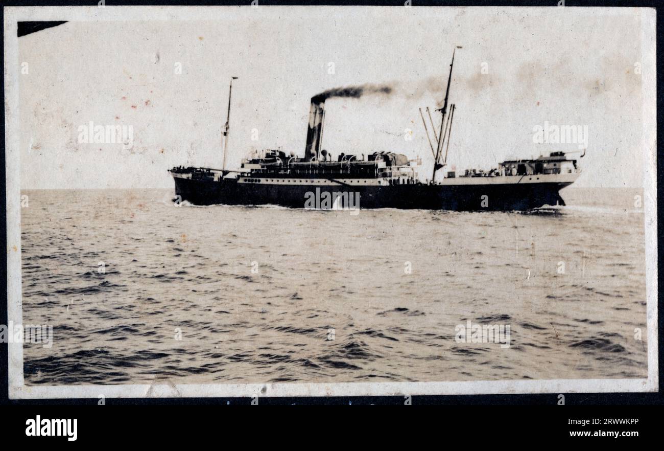 Side view of the SS Inanda, seen from across water, possibly from another ship. Smoke is blowing out of her stack. Original manuscript caption: SS Innanda. Stock Photo