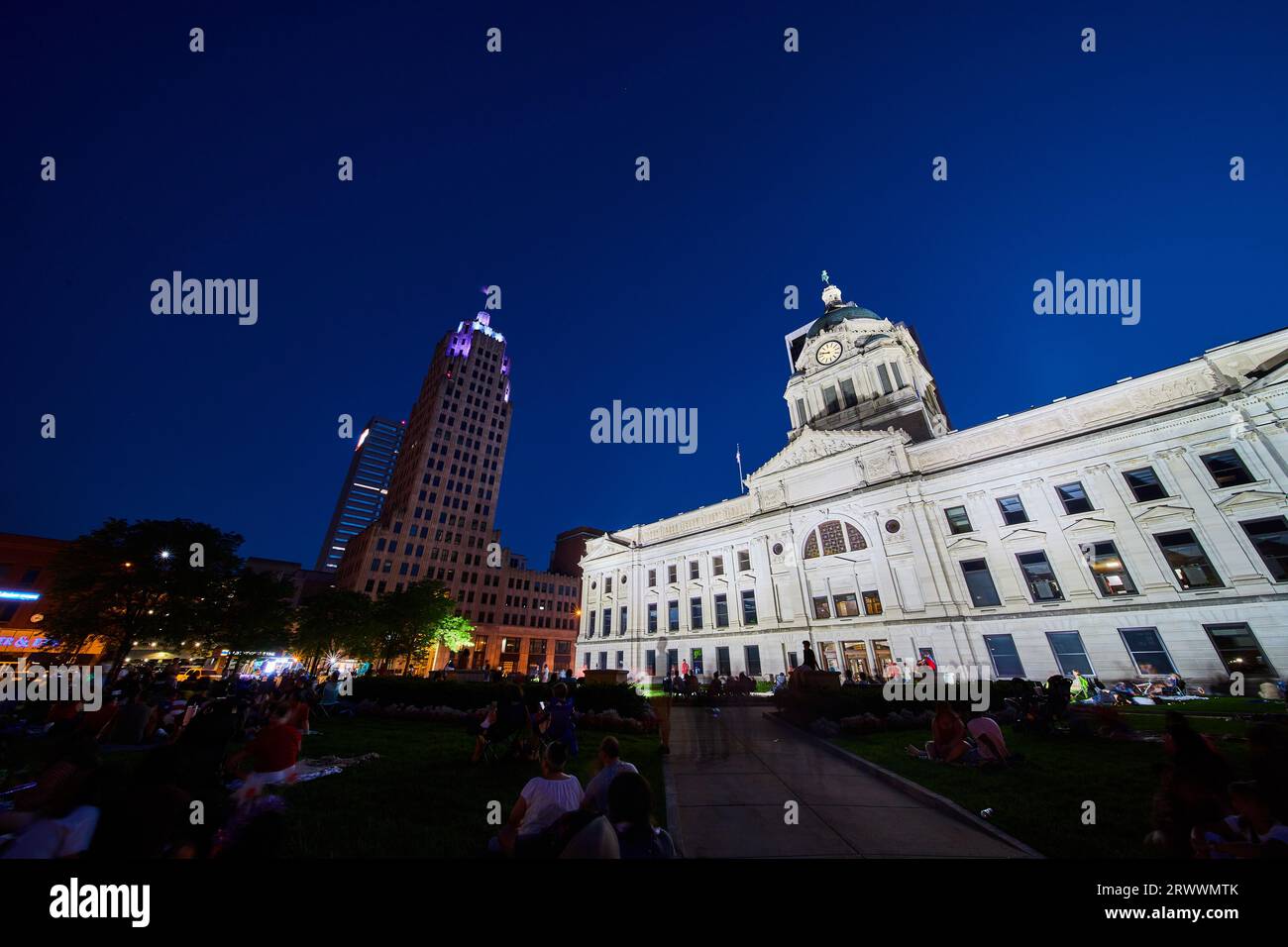 Crowd of people on Allen County Courthouse lawn at night with illuminated buildings Stock Photo