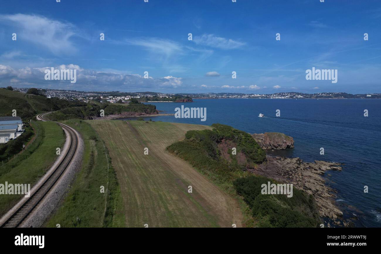 Waterside Park, Torbay, South Devon, England: Steam railway line, Armchair Cove and the Torbay sea. Torbay is a popular UK summer holiday resort. Stock Photo