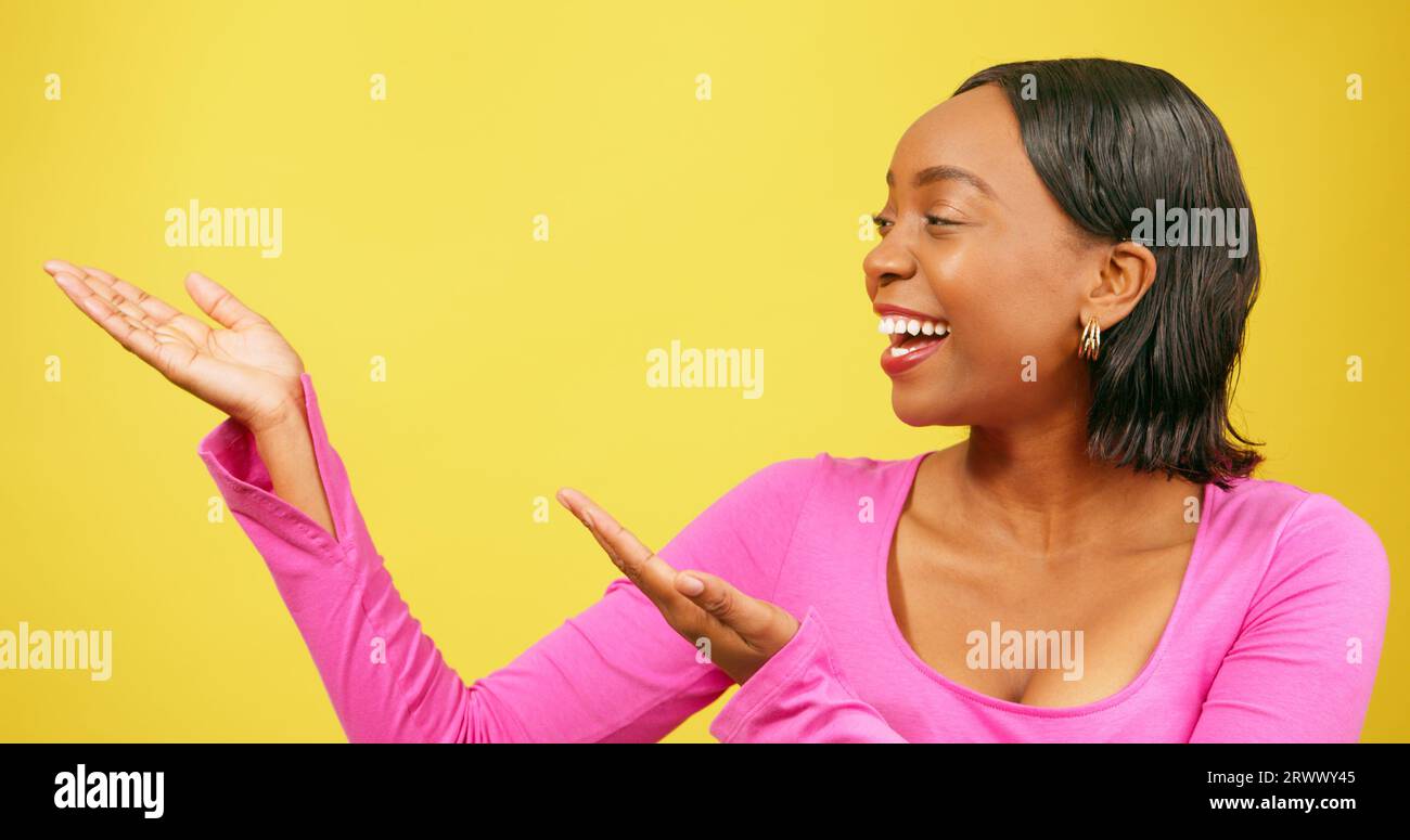 Beautiful Black woman uses both palms gesturing upwards looking to copy space Stock Photo