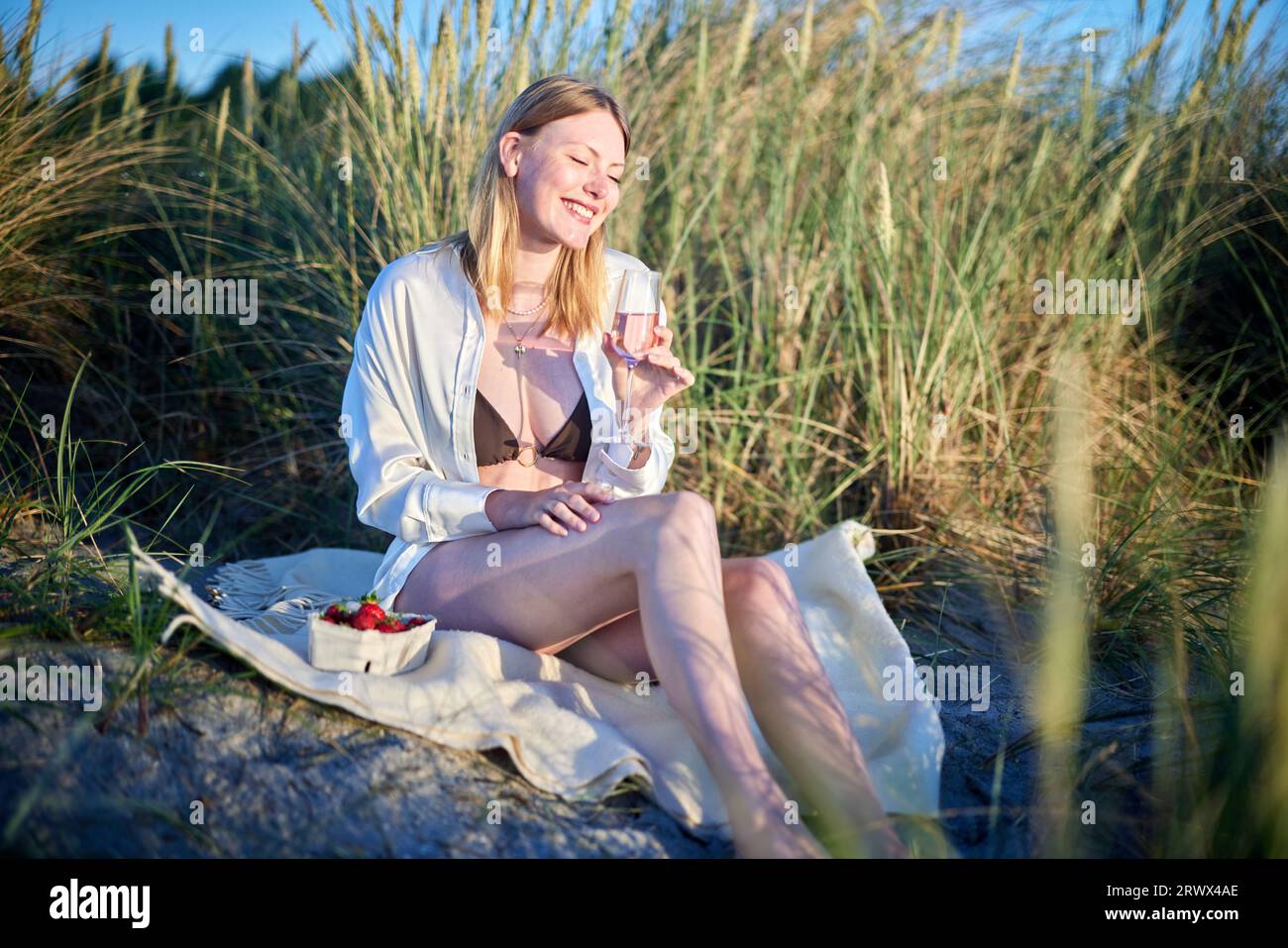 girl drinking wine on the beach Stock Photo