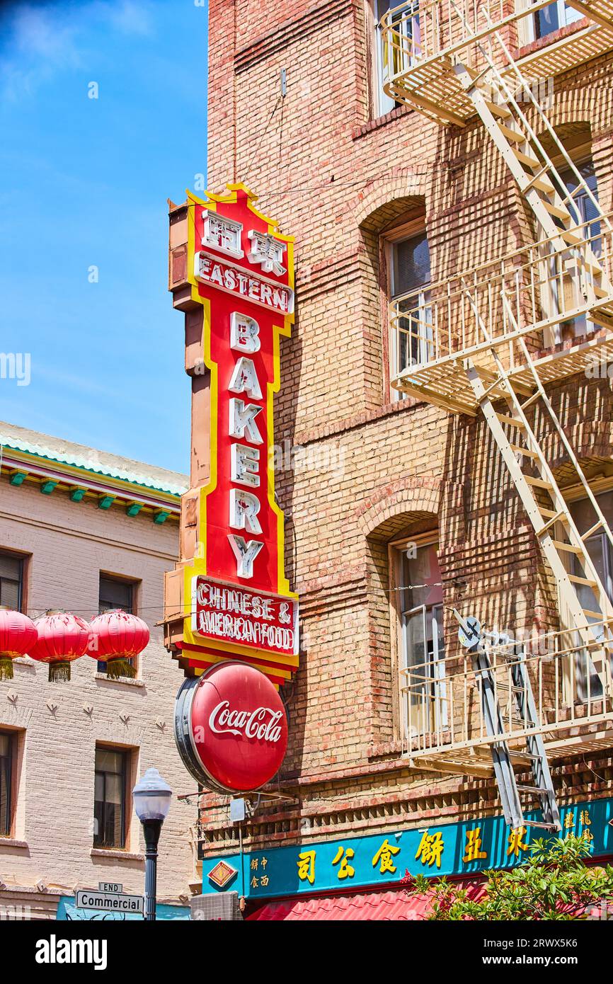 Large sign for bakery on side of tan brick building with light yellow ...