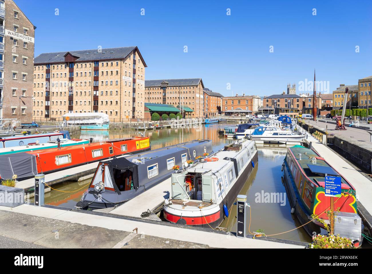 Gloucester docks narrowboats in Victoria Basin with Victorian warehouses converted into apartments Gloucester Gloucestershire England UK GB Europe Stock Photo