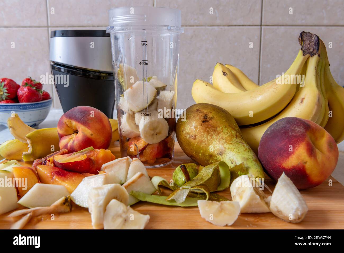 Making a smoothie with fresh fruits in a blender. Healthy life style, health food concept. Stock Photo