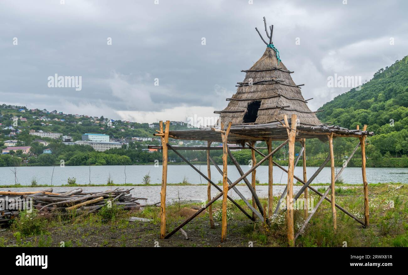 The replica of indigenous people's house, the lake and the green hills in the downtown of Petropavlovsk-Kamchatsky in Kamchatka, Russia Stock Photo