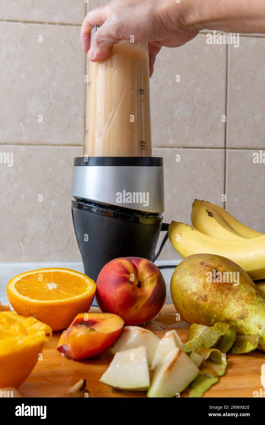 Making a smoothie with fresh fruits in a blender. Healthy life style, health food concept. Stock Photo