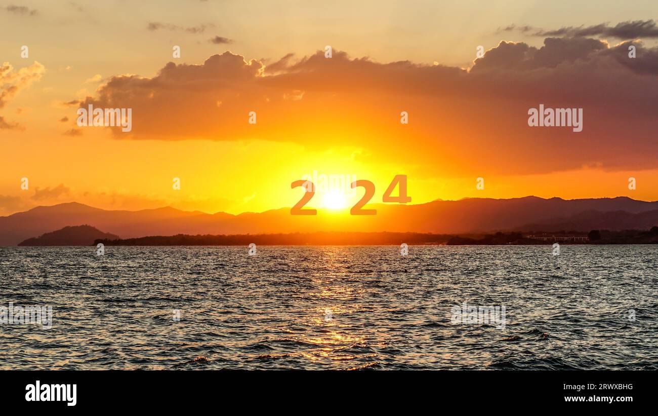 Happy New Year 2024 anniversary. Transition from 2023 to new year 2024 concept with text on sun rising sky. Photo image can be used as large banner. Stock Photo