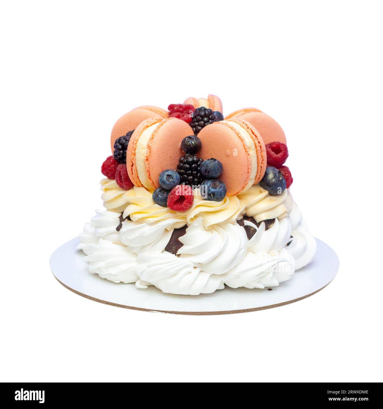 Pavlova cake with fresh berries and giant pink macarons, whipped cream and chocolate sauce isolated on white background, png Stock Photo