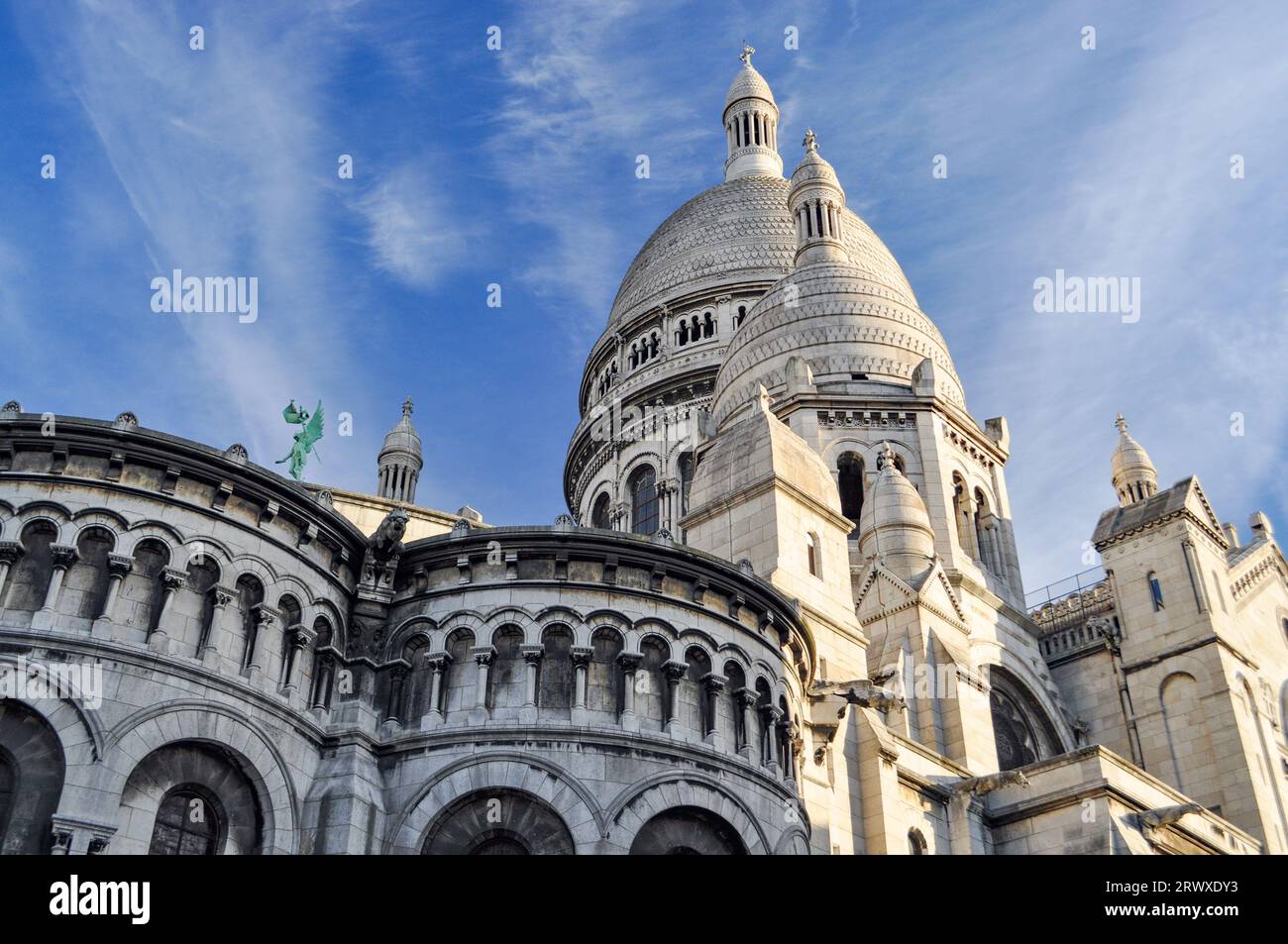 Sunlit facade of the side of the Sacré Coeur Basilica including its domes in Montmartre, Paris, France Stock Photo