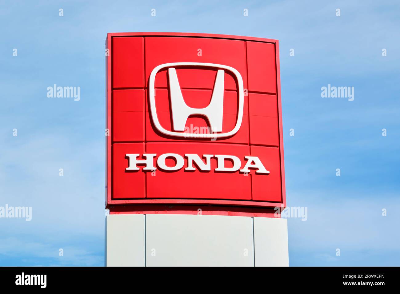 Honda sign outside in front of a Honda auto dealership photographed in portrait orientation. Stock Photo
