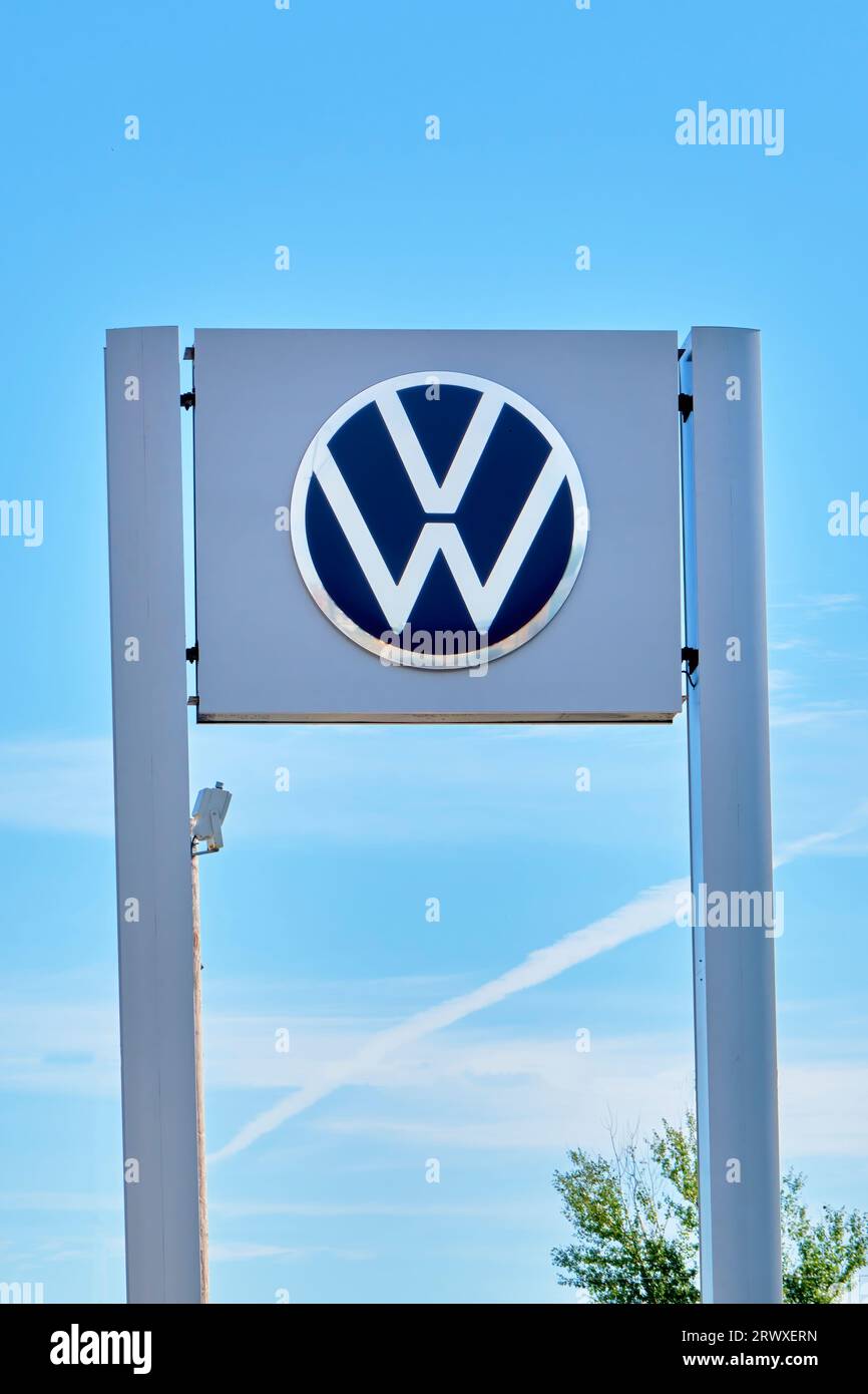 Volkswagon sign outside in front of a Honda auto dealership photographed in portrait orientation. Stock Photo
