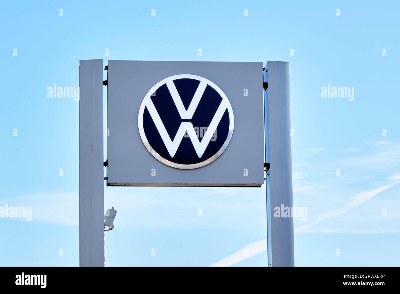 Volkswagon sign outside in front of a Honda auto dealership photographed in portrait orientation. Stock Photo