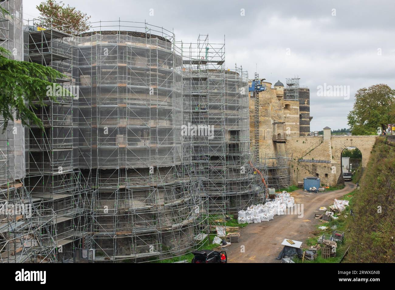 Angers, France, 2023. The scaffolding around the round towers and in the moat, with the main entrance to the medieval castle in the background Stock Photo