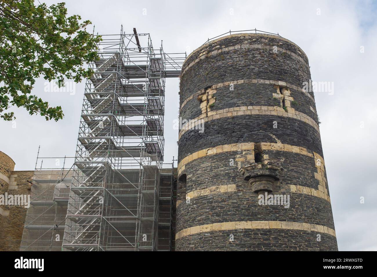 Angers, France, 2023. Overlooking the River Maine, the round tower known as the Tour du Moulin with scaffolding during restoration Stock Photo