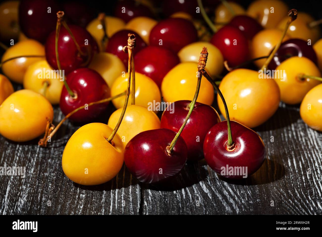 red yellow cherry on wood background Stock Photo - Alamy