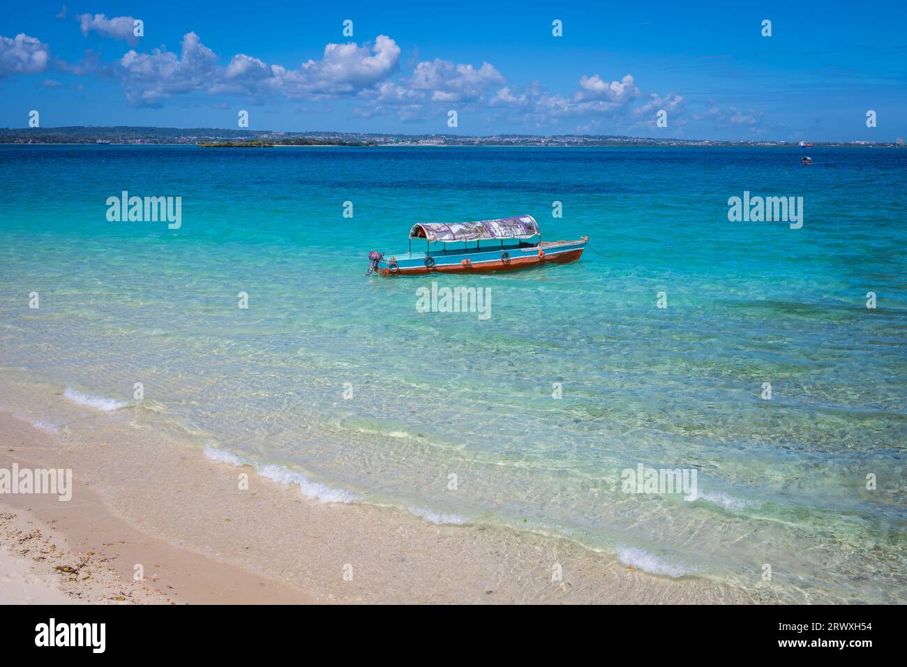 Boats floating parked by a sand bank in Zanzibar, Tanzania Stock Photo