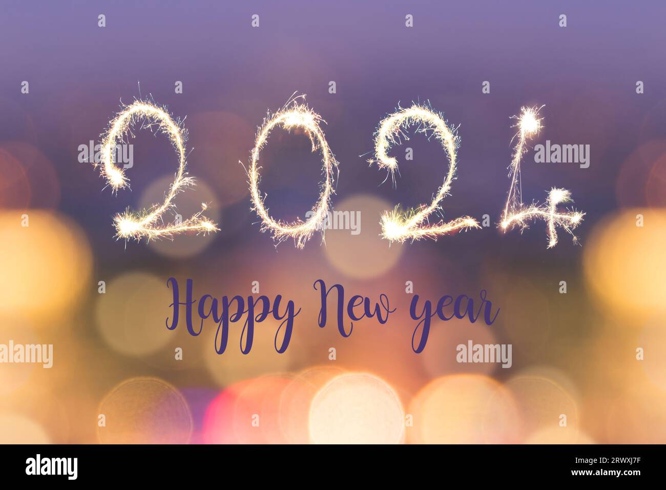 Happy new year 2024 written with sparkles on blurred bokeh lights background, holiday greeting card Stock Photo
