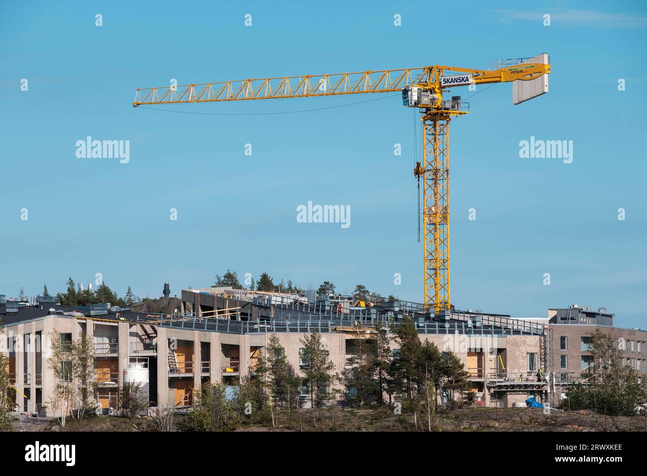 Helsinki / Finland - SEPTEMBER 18, 2023: A construction crane against a bright blue sky. Operated by Swedish multinational construction and developmen Stock Photo
