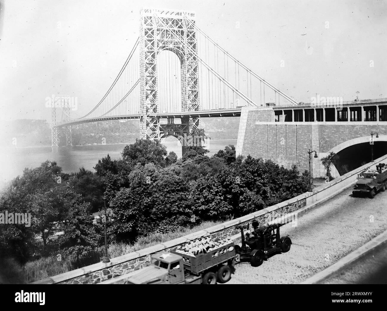 Army trucks on the road close to the George Washington Bridge, New York. Rare photograph: From a collection compiled by an unknown British serviceman covering the No. 1 Composite Demonstration, AA Battery, tour of the USA, from July 11th 1943. This is one from over one hundred images in the collection which were on average around 4x3 inches. Stock Photo