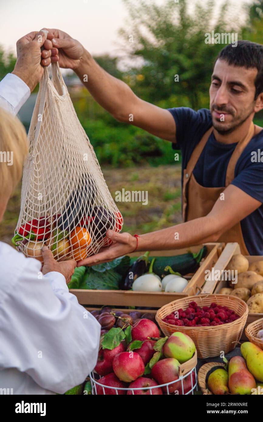The farmer sells fruits and vegetables at the farmers market. Selective ...