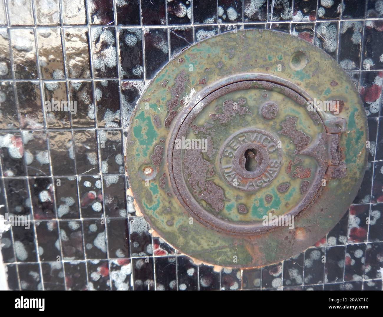 Old round door of a water meter located on the facade of a house Stock