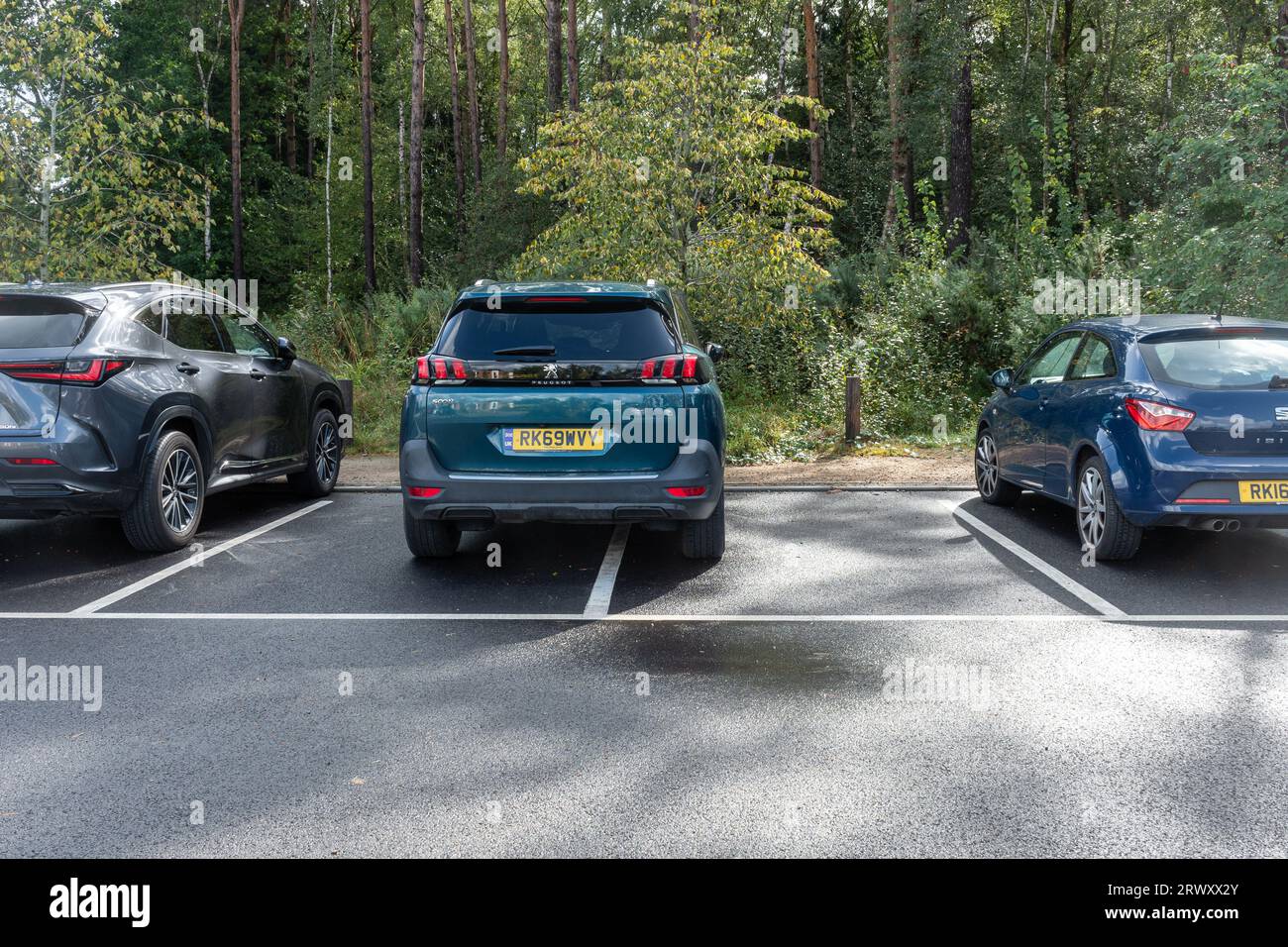 Inconsiderate parking, car parked on line taking up two car park spaces, UK Stock Photo