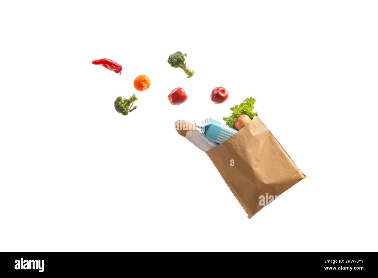 Paper shopping bag with products in the air falling isolated on white background Stock Photo