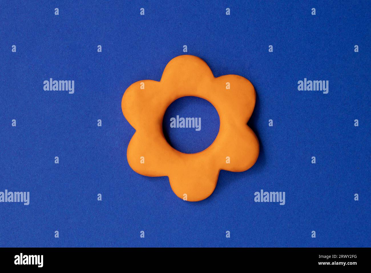 Simple three dimensional sign of flower. Symbol of prosperity, growth concept, growing buissnes. Orange flower icon on blue background, environmental, Stock Photo